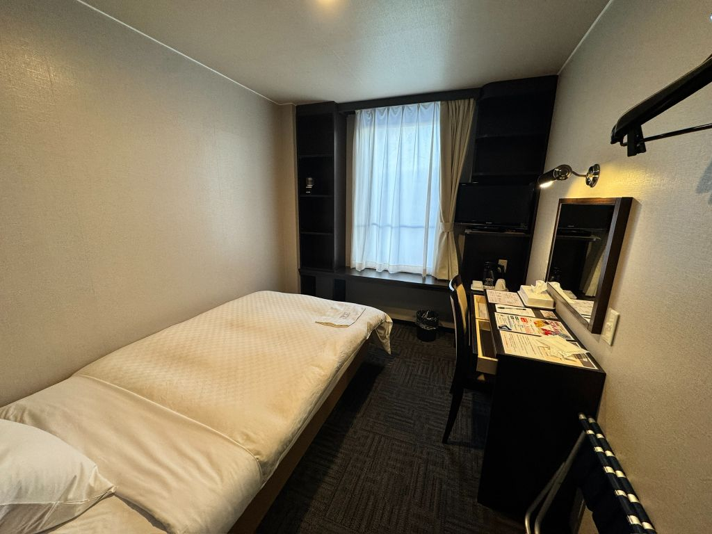 ホテルサンシャインのシングル客室（ベッドとデスク、テレビのあるシンプルな部屋）